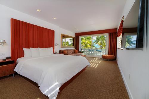 sypialnia z dużym białym łóżkiem z czerwoną ścianą w obiekcie The Tony Hotel South Beach w Miami Beach