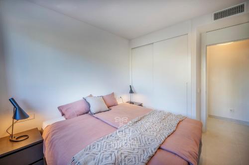 a bedroom with a large bed with pink pillows at HigueronRentals Casa Kiki in Málaga