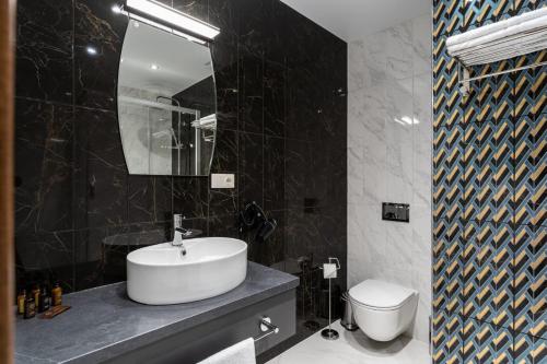 a black and white bathroom with a sink and a toilet at Old Riga Plaza Hotel in Riga