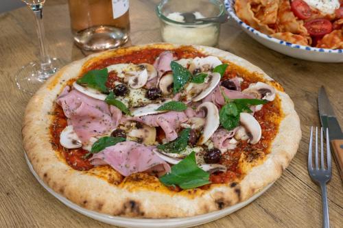 a pizza sitting on top of a plate on a table at ibis Dunkerque in Dunkerque