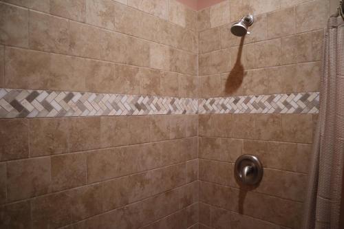a shower with a shower head in a bathroom at Magnolia Creek Lodge in Cottonwood