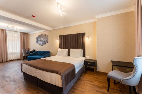 a hotel room with a bed and a blue chair at Old Riga Plaza Hotel in Riga
