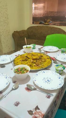 a table topped with a pizza and bowls of food at Petra Stones Inn in Wadi Musa