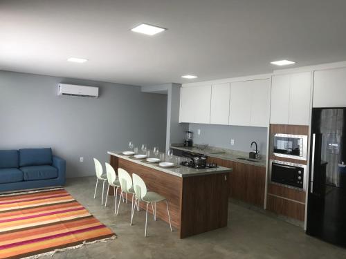 cocina con encimera con sillas y sofá azul en Pousada Ohana Dullius, en São Francisco do Sul