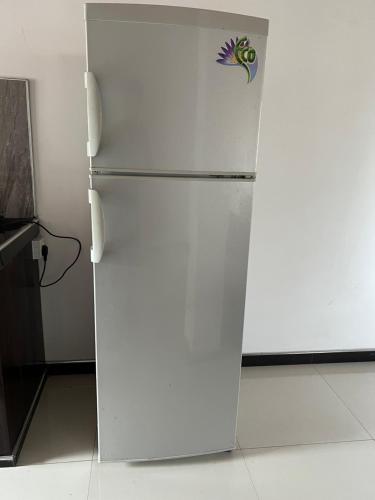 a white refrigerator in a kitchen with a sticker on it at Tanzanite place in Tangalle