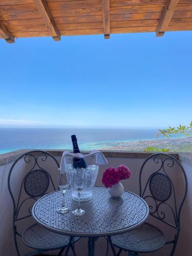 a table with wine glasses and flowers on a balcony at Il Capanno in Pietra Ligure