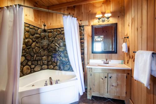 un baño con bañera y lavabo en Little Cub Retreat Mtn View, Hot Tub, Indoor Pool, en Gatlinburg