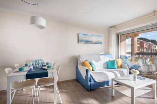 un salon avec un canapé bleu et une table dans l'établissement Face Mer appartement pour 4 personnes, à Pornic