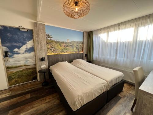 a bedroom with a bed and a large window at Hotel Nap in West-Terschelling