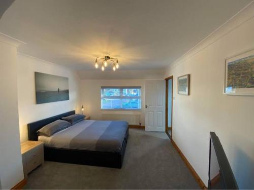 1 dormitorio con cama y ventana en The Meadows St Teath, 4 bed sleeps 7 en Saint Teath