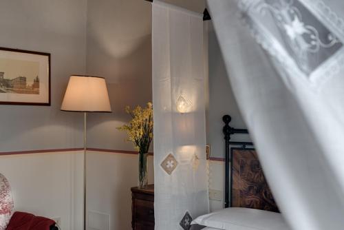 Un dormitorio con una cama y un jarrón de flores. en Tenuta Il Corno Agriturismo, en San Casciano in Val di Pesa