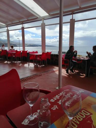 a restaurant with tables and chairs and a view of the ocean at Anaga y La laguna a tus pies in Santa Cruz de Tenerife