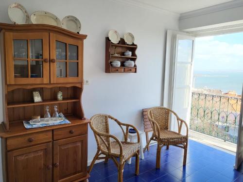 a dining room with a table and chairs and a window at Pilar - Alfama River View in Lisbon