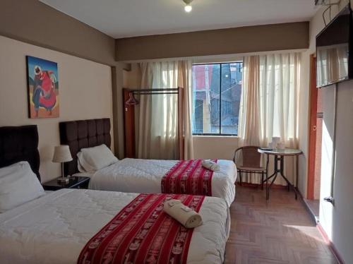 um quarto de hotel com duas camas e uma janela em Hermoza House em Cusco