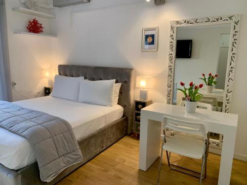 una camera con letto, specchio e scrivania di Residence Villa Alba a Gardone Riviera