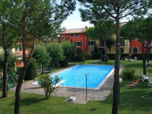 a swimming pool in a yard next to a house at Gardappartamenti Campiello Pool in Sirmione