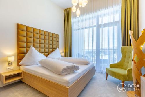 a bedroom with a bed and a chair and a window at TATRA SUITES Luxury Studio C408 in Smokovce
