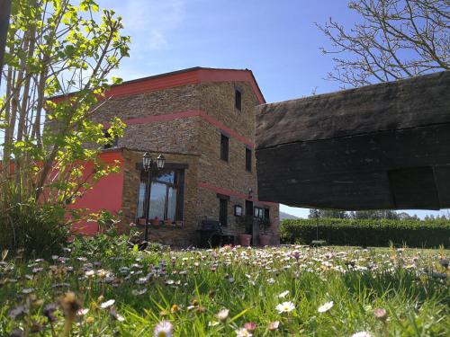 un edificio de ladrillo con flores delante en A Lume Manso - Adults Only, en Barreiros