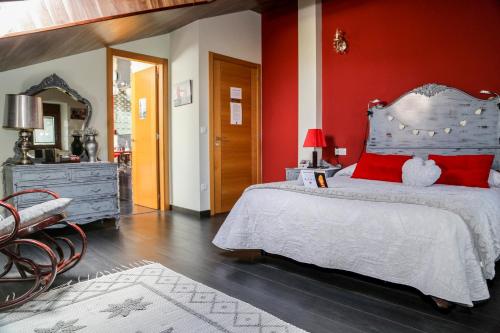 a bedroom with a bed and a red wall at A Lume Manso - Adults Only in Barreiros