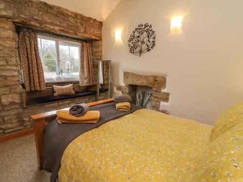 a bedroom with a bed and a stone wall at Cobble Cottage in Burton in Lonsdale