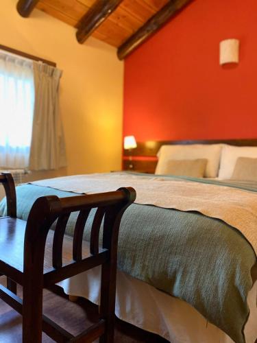 a bedroom with a bed with a red wall at Infinito Sur in El Chalten