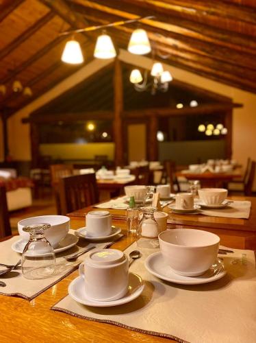 a wooden table with cups and saucers on it at Infinito Sur in El Chalten