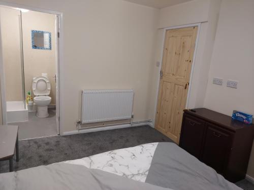 a bedroom with a bed and a bathroom with a toilet at 2-Beds Studio Located in Parkgate Rotherham in Rotherham