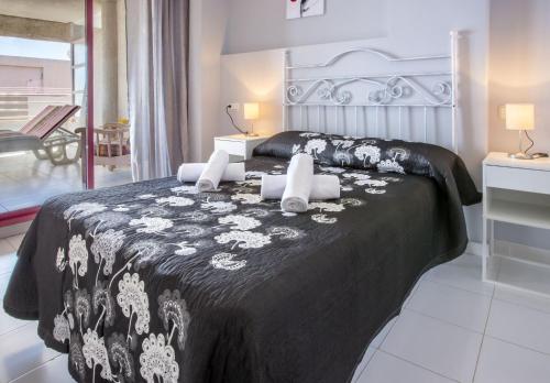 een slaapkamer met een bed met een zwart-witte deken bij Apartamentos Nuevo Mexico (9º-C) in Calpe