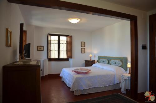 een slaapkamer met een bed, een wastafel en een spiegel bij Donnaberarda in Cortona