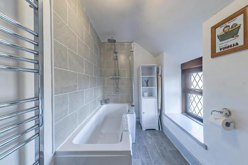 a bathroom with a bath tub and a window at Gwynfryn in Cerrig-y-Druidion