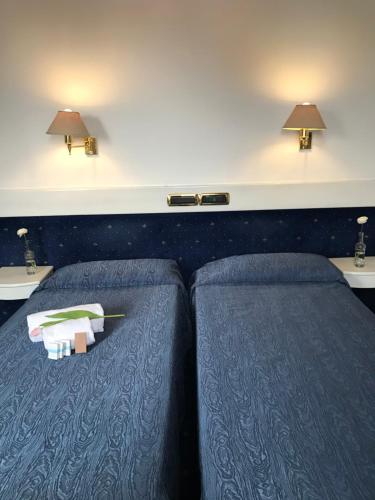 a hotel room with two beds and two lamps at Eurohotel in Piacenza