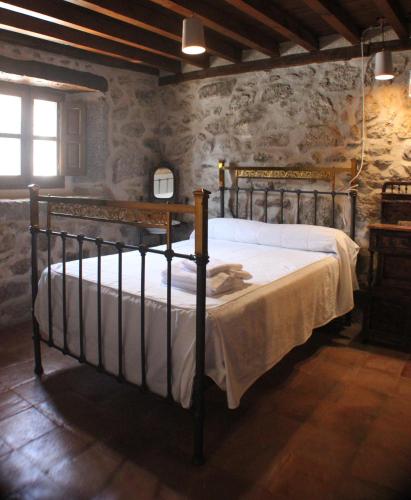 a bedroom with a bed in a room with stone walls at La Centenaria de Alaraz in Alaraz