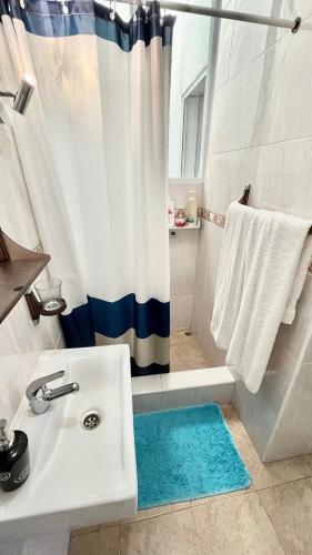 a bathroom with a white sink and a shower at Paraíso Azul, AL in Vila Franca do Campo