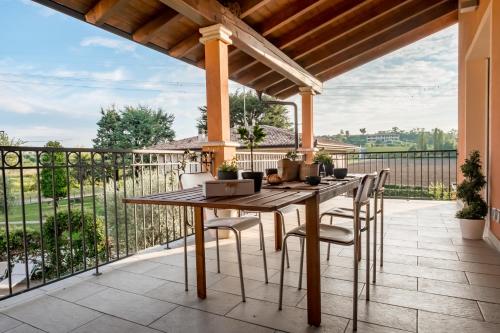 Un patio al aire libre con una mesa y sillas de madera. en Residenza Oleandro, en Desenzano del Garda