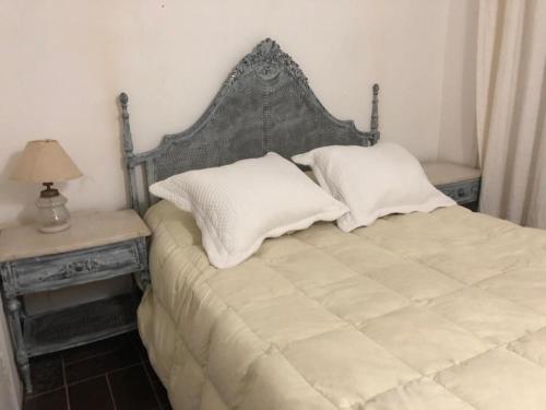 a bedroom with a bed with two pillows and a table at Chalet En La Paloma A 2 De Playa Los Botes (hermosa Zona) in La Paloma
