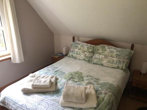 a bedroom with a bed with two towels on it at Foresters Lodge bed and breakfast, near loch ness in Inverfarigaig