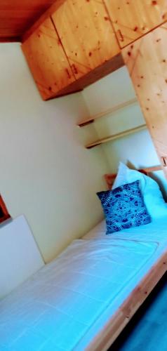 a bed in a room with a wooden ceiling at Ferienwohnungen Miklautsch in Faak am See