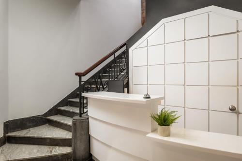 a staircase with white tiled walls and a stair case at BYPILLOW Amari in Bilbao