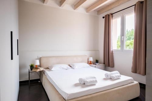 デセンツァーノ・デル・ガルダにあるResidenza Gelsominoの白いベッドルーム(ベッド1台、タオル2枚付)