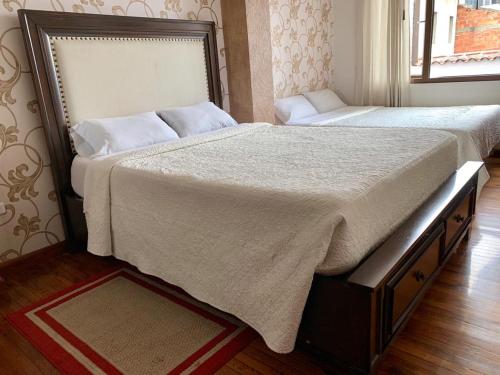 two beds sitting next to each other in a bedroom at Hotel Azul de la Plaza by Chat Noir in Cuenca