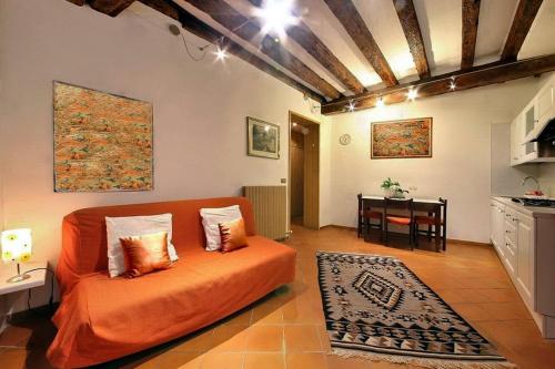 a living room with an orange bed and a table at Ca Lucia in Venice