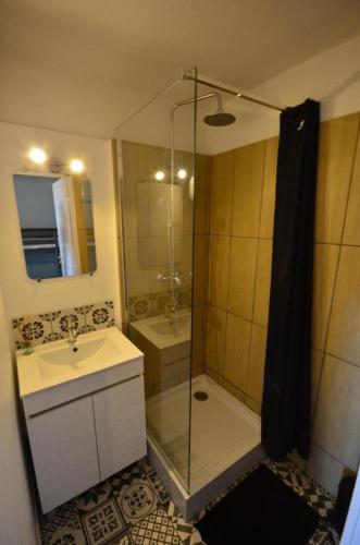 une salle de bain avec une douche en verre et un lavabo dans l'établissement Studio vue mer, à Valras-Plage