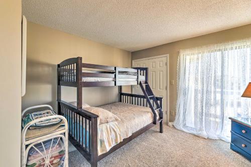a bedroom with a bunk bed and a window at Coastal Condo with Indoor and Outdoor Pool Access in Emerald Isle