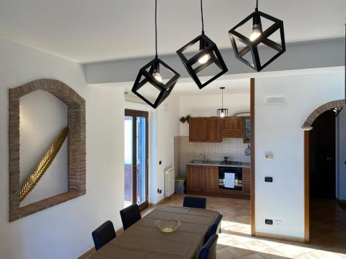 a dining room with a table and a kitchen at Casa Pasitea in Taormina