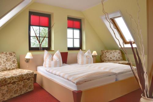 a bedroom with a bed and two windows at Hotel & Restaurant Waldblick in Pulsnitz