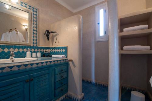 bagno con lavandino e specchio di L’oasis de kima a Taroudant