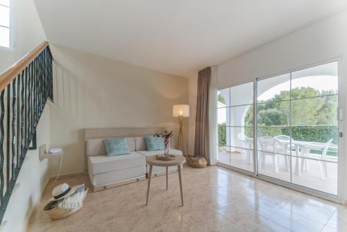 a living room with a couch and a table at Hotel Moon Dreams Marina Parc in Na Macaret
