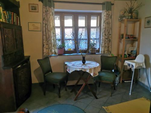 a table and chairs in a room with a window at Lóci Palócház in Nagylóc
