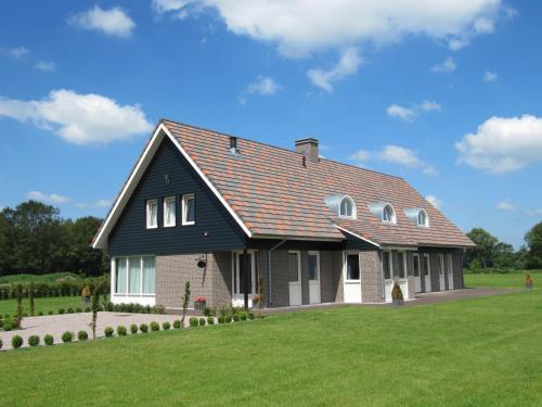 uma casa com um telhado preto num campo verde em Vakantiehuis B&B Familie Versantvoort em Handel