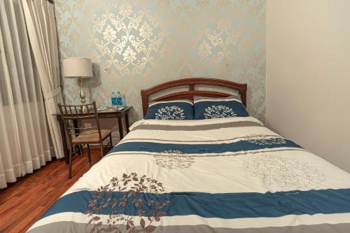 a bedroom with a bed with blue and white sheets at Hotel Azul de la Plaza by Chat Noir in Cuenca
